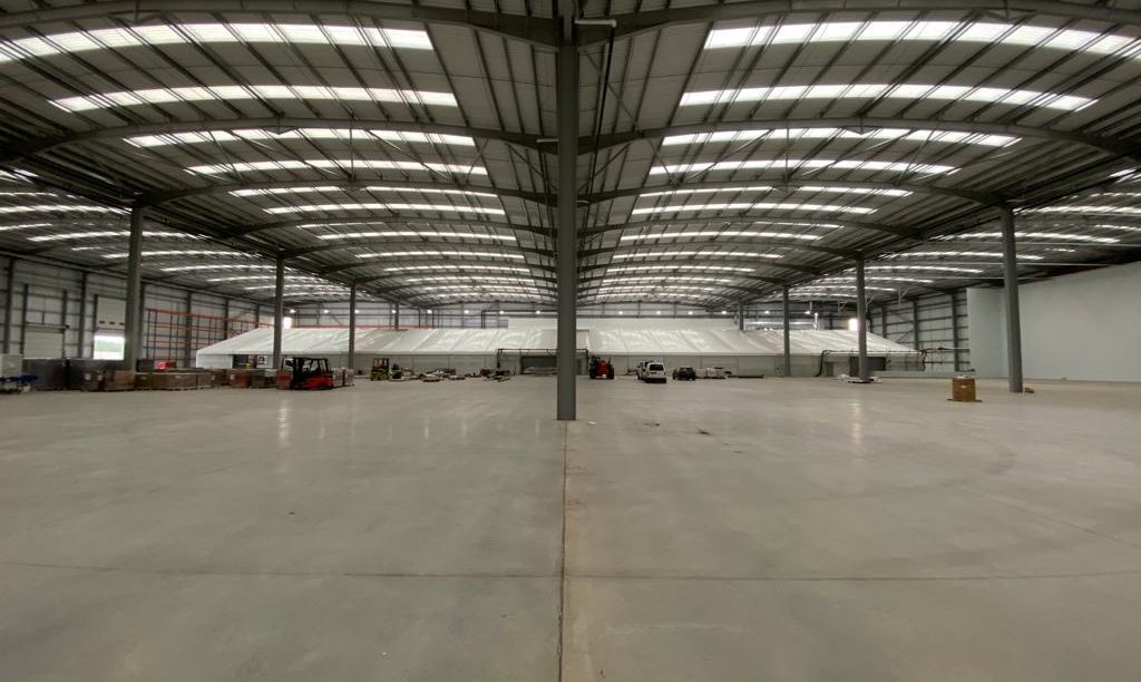 A temporary building installed into a larger warehouse space for logistics operations
