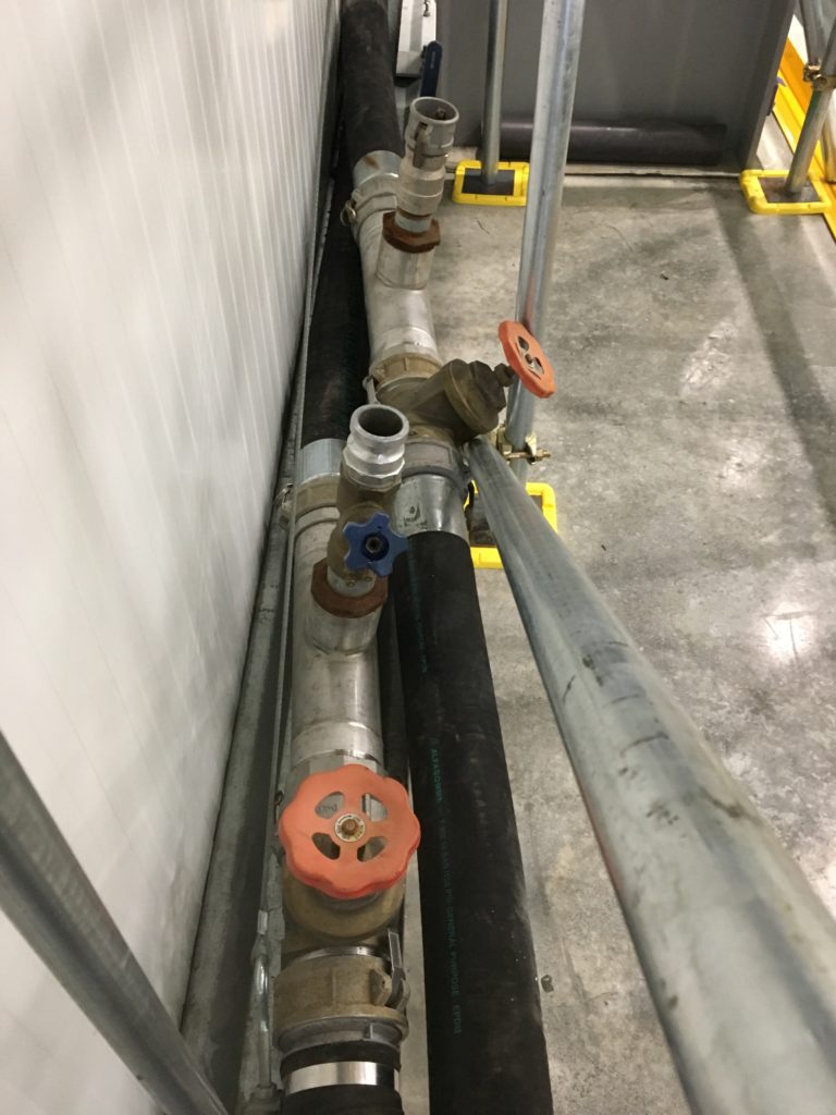 Temporary chiller water pipework and camloc fittings installed as part of a larger chilled water systems at a logistics warehouse.